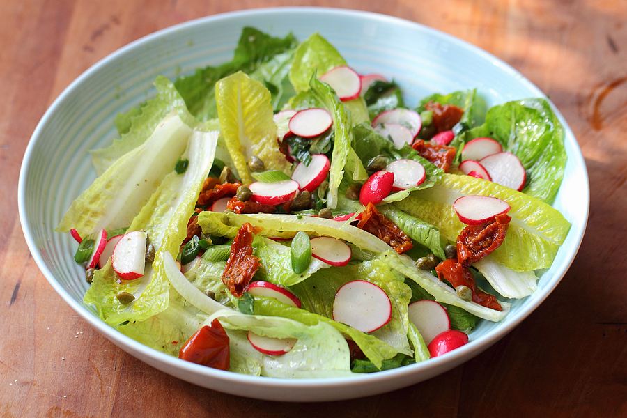 Lettuce salads with radishes, dried tomatoes and capers